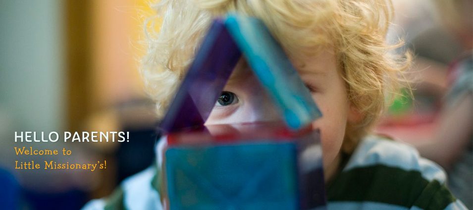 Hello parents! Welcome to Little Missionary's! A child peeks through a house built of magnetic tiles.